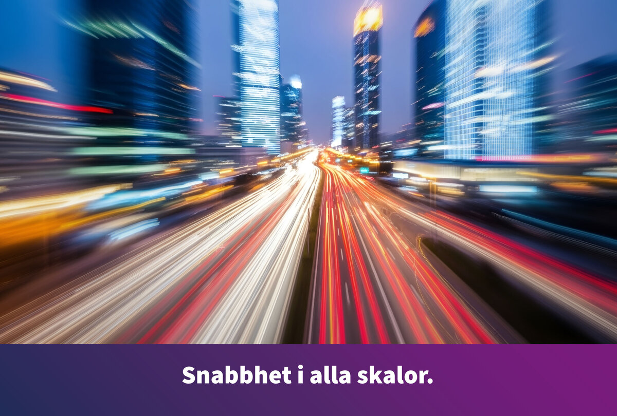 Nattvy &ouml;ver en modern storstad med skyskrapor och en flerfilig v&auml;g. Ljussp&aring;ren fr&aring;n passerande fordon f&ouml;rmedlar en k&auml;nsla av h&ouml;g hastighet. L&auml;ngs bildens nederkant st&aring;r texten: &raquo;Snabbhet oavsett skala.&laquo;