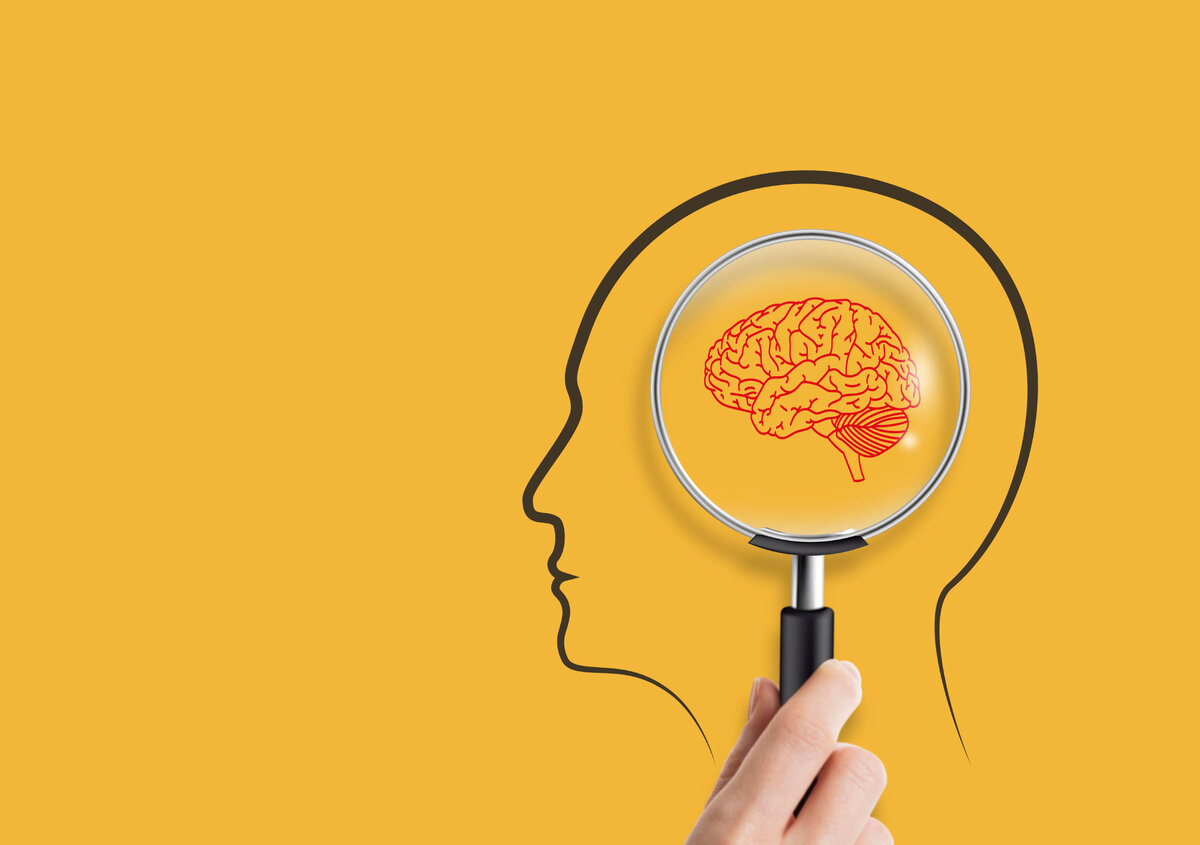 Illustration of a human head outline with a magnifying glass highlighting a brain, symbolizing mental health, psychological assessment, cognition, and workplace wellbeing against a yellow background.