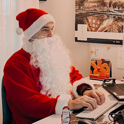 Bild vergr&ouml;&szlig;ern: Fotoaufnahme Schreibtisch mit Notebook im Hintergrund und Schokoladennikolaus.